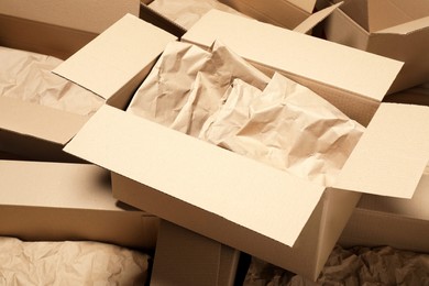 Many open cardboard boxes with crumpled paper as background