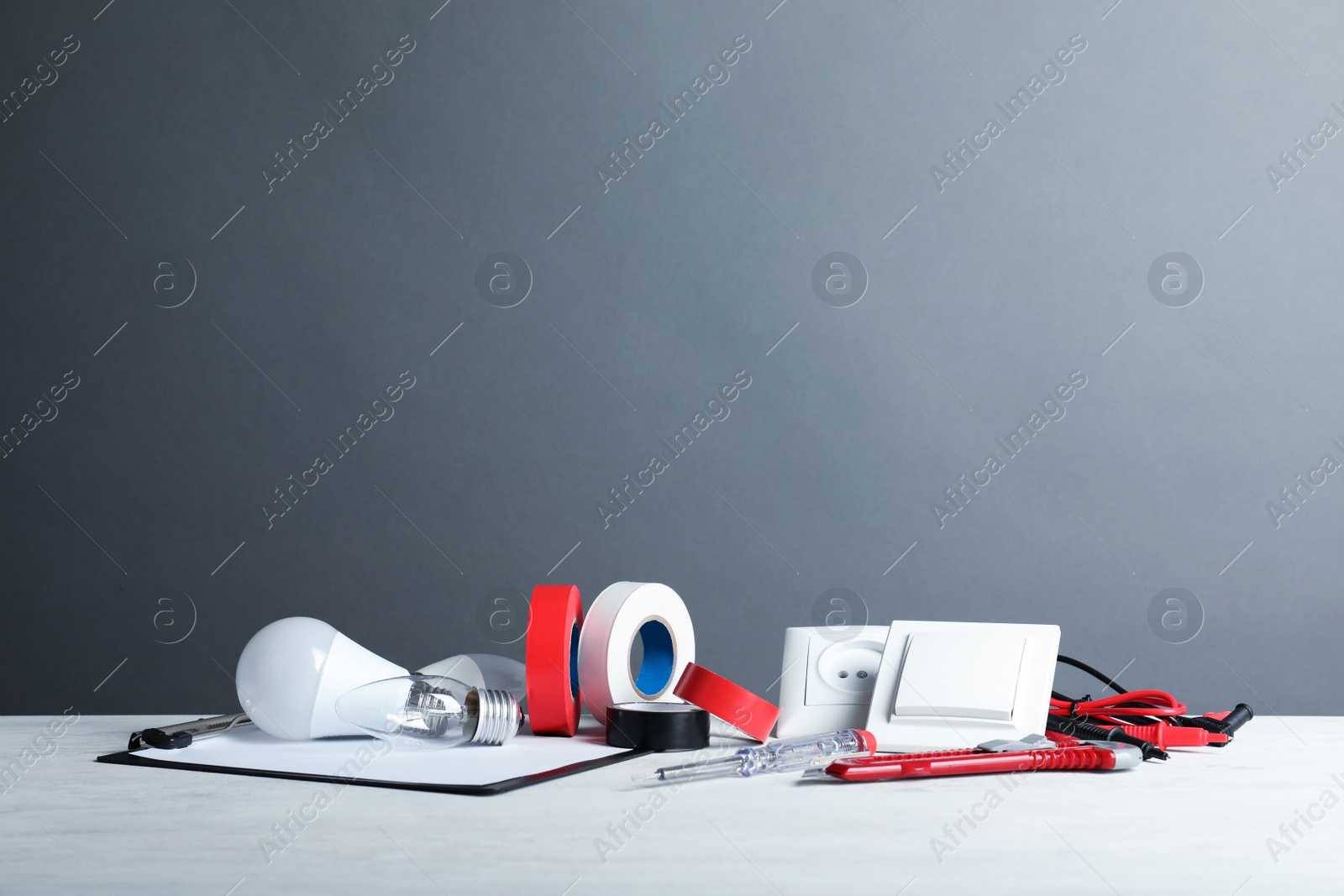 Photo of Set of electrician's tools on table against gray background. Space for text