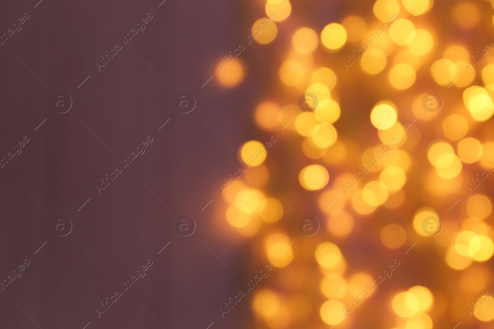 Photo of Blurred view of Christmas lights on color background, space for text