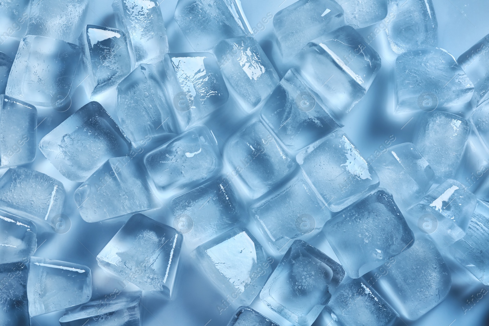 Photo of Many ice cubes on color background, top view