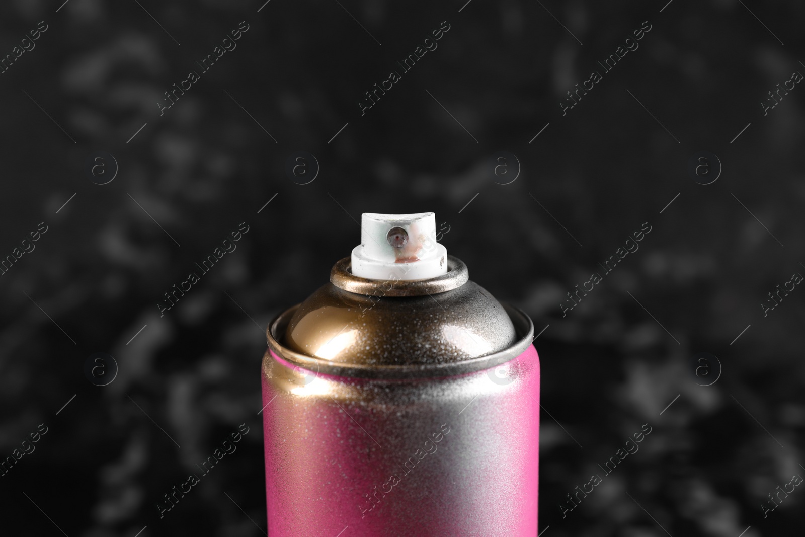 Photo of Used can of spray paint on black marble background, closeup
