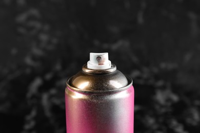 Photo of Used can of spray paint on black marble background, closeup