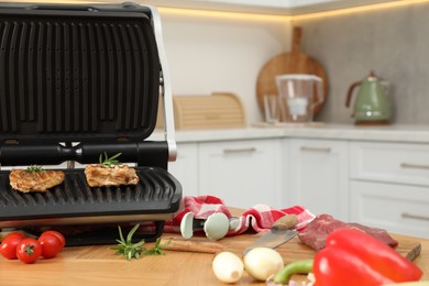 Photo of Electric grill and different products on wooden table