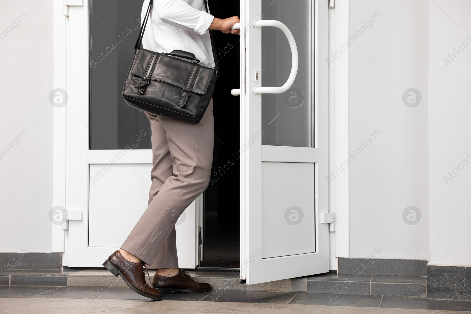 Photo of Man with briefcase leaving or entering building, closeup view