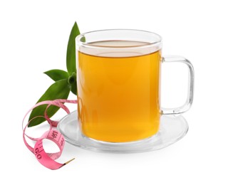 Photo of Glass cup of diet herbal tea, measuring tape \and fresh leaves on white background. Weight loss