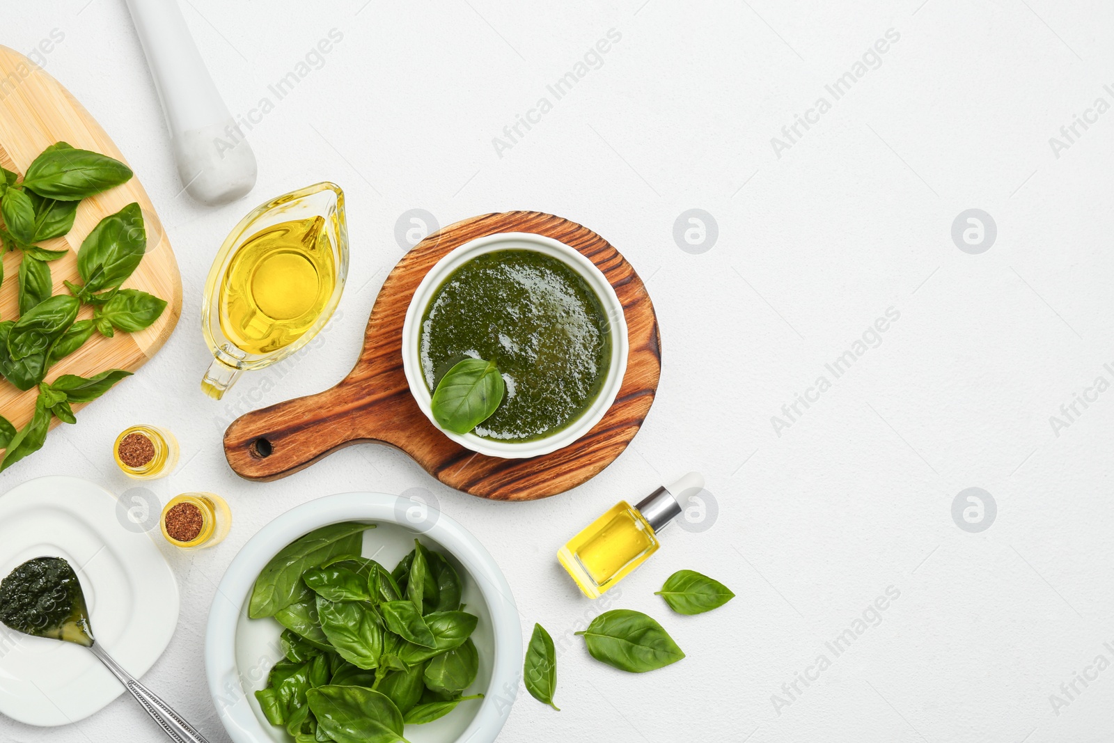 Photo of Flat lay composition with basil oil, leaves and space for text on white table