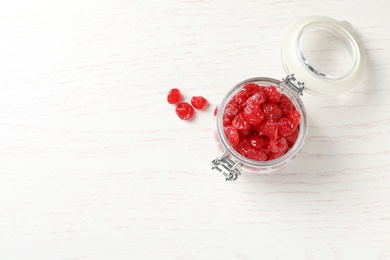 Jar of tasty cherries on wooden background, top view with space for text. Dried fruits as healthy food