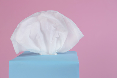 Photo of Box with paper tissues on pink background, closeup