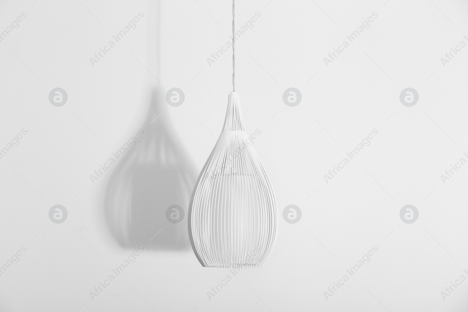 Photo of Modern lamp hanging on white background. Idea for interior design