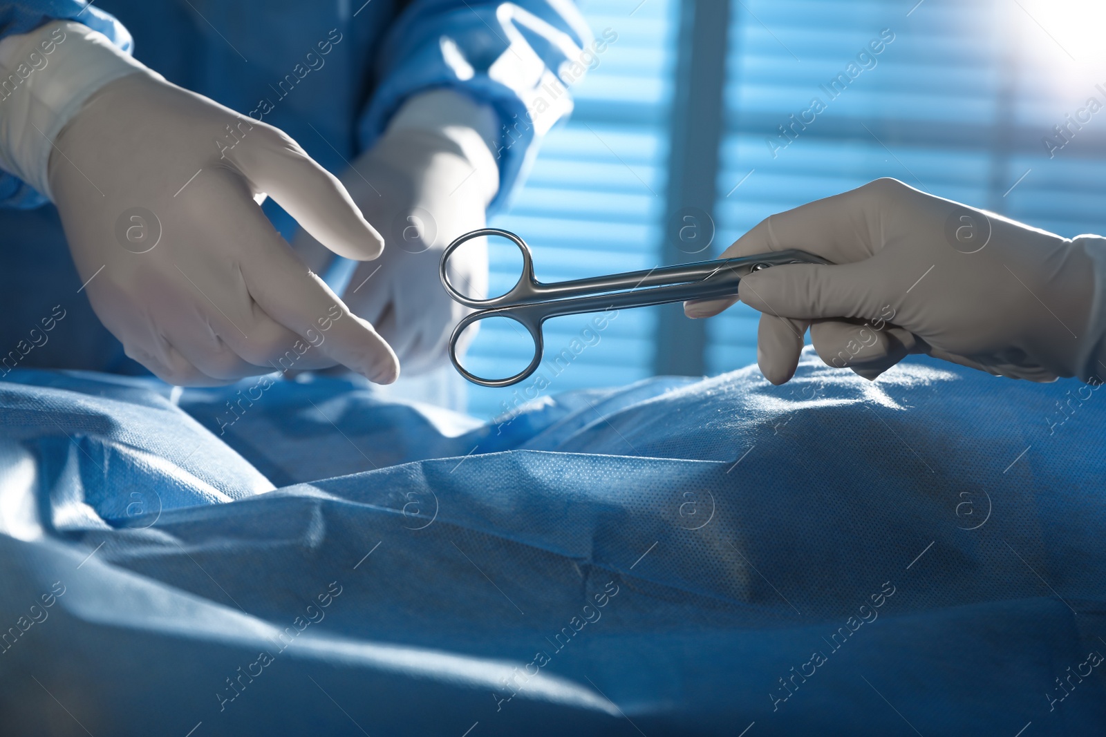 Photo of Professional surgeons with instruments performing operation in clinic, closeup