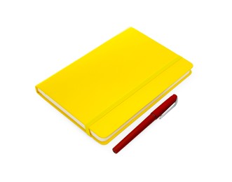Photo of Closed yellow notebook with pen isolated on white
