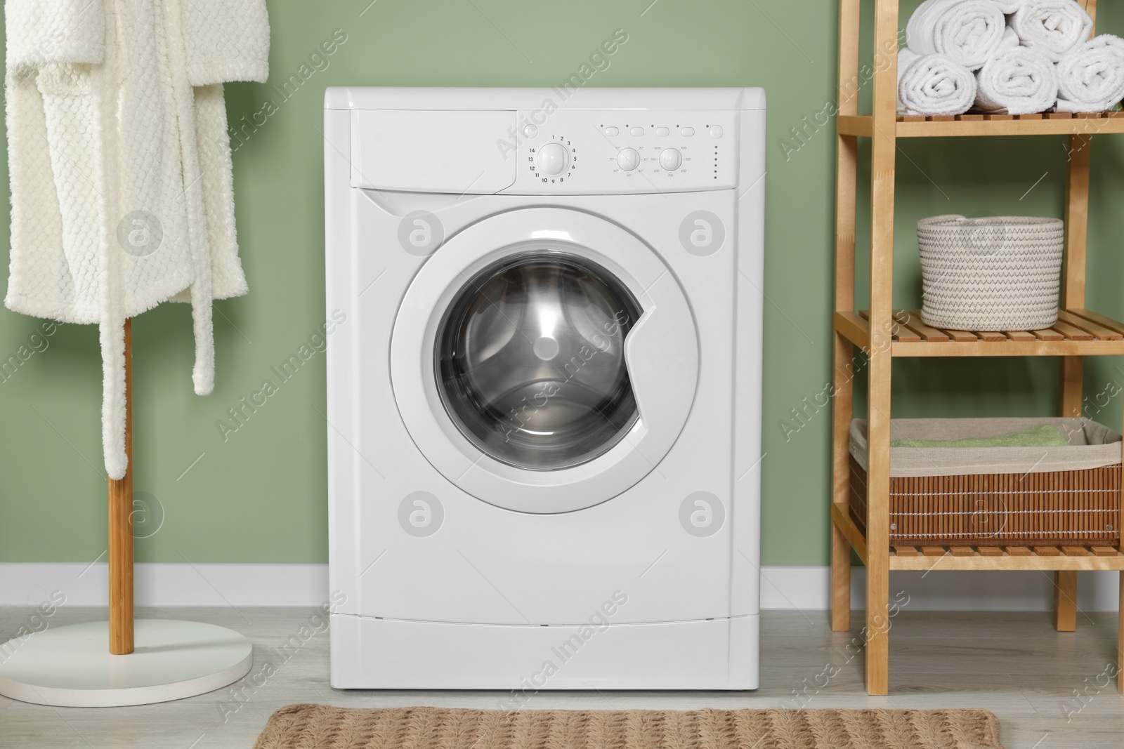 Photo of Stylish laundry room with washing machine. Interior design