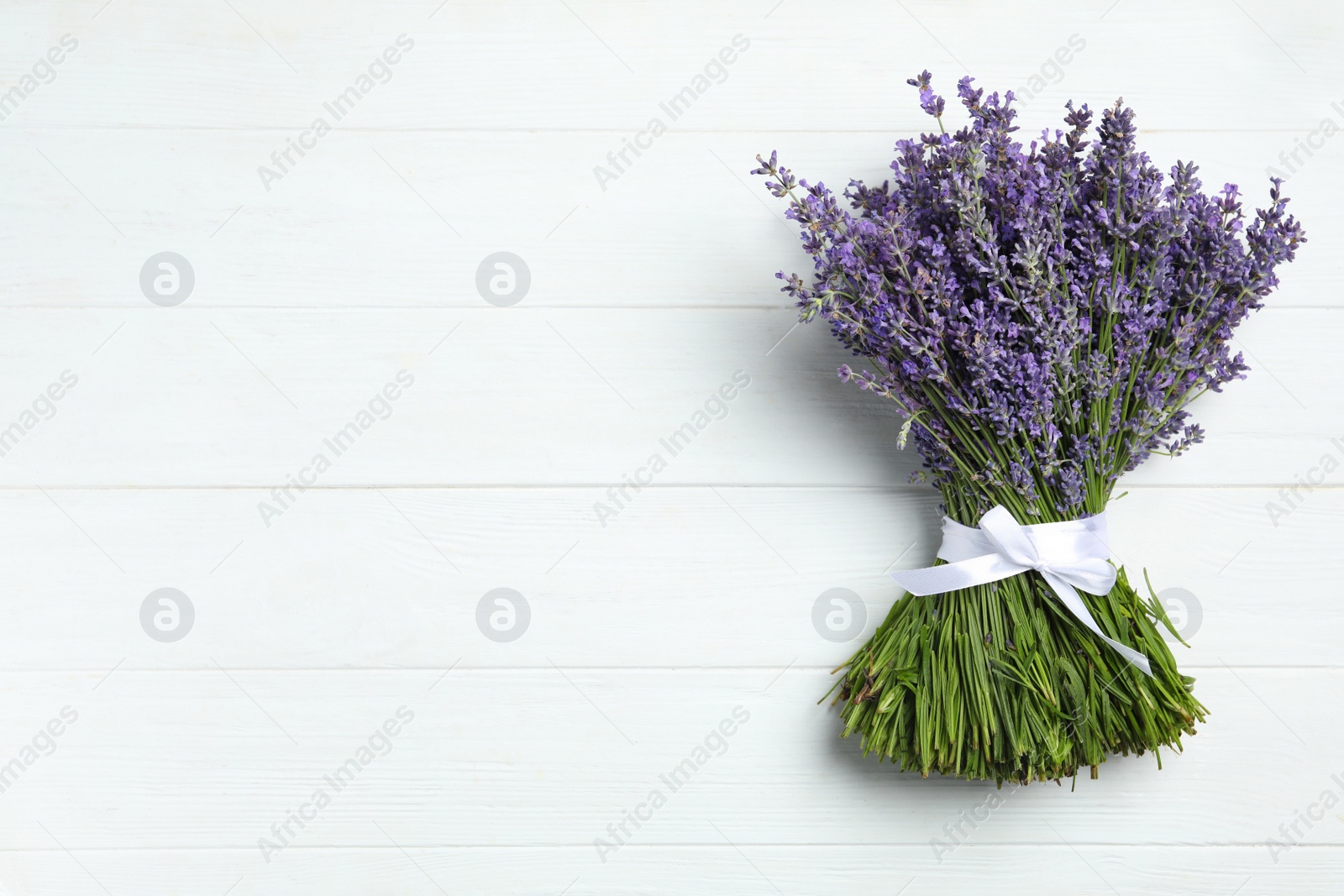 Photo of Beautiful lavender bouquet on white wooden background, top view. Space for text
