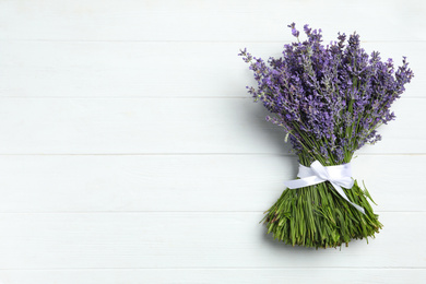 Beautiful lavender bouquet on white wooden background, top view. Space for text