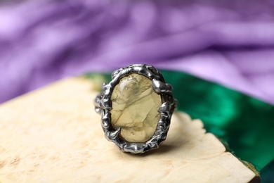 Photo of Beautiful silver ring with prehnite gemstone on textured surface