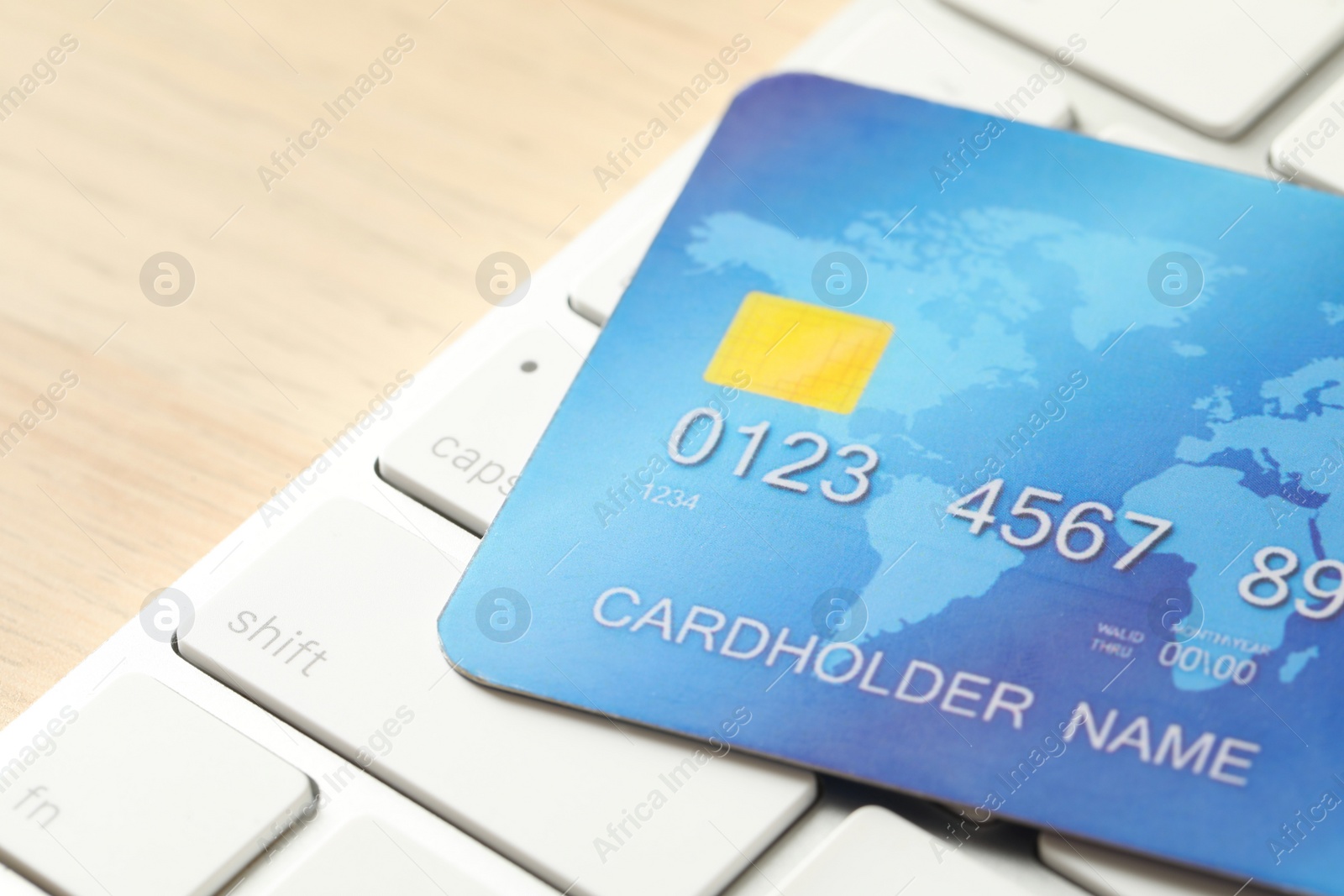 Photo of Online payment concept. Bank card and computer keyboard on table, closeup