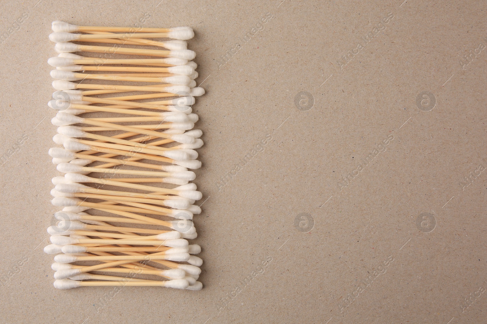 Photo of Many clean cotton buds on cardboard, flat lay. Space for text