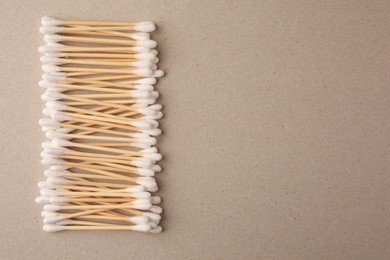 Photo of Many clean cotton buds on cardboard, flat lay. Space for text