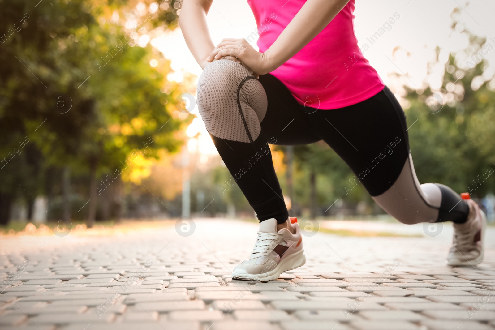 Photo of Woman stretching before morning run in park, closeup. Space for text