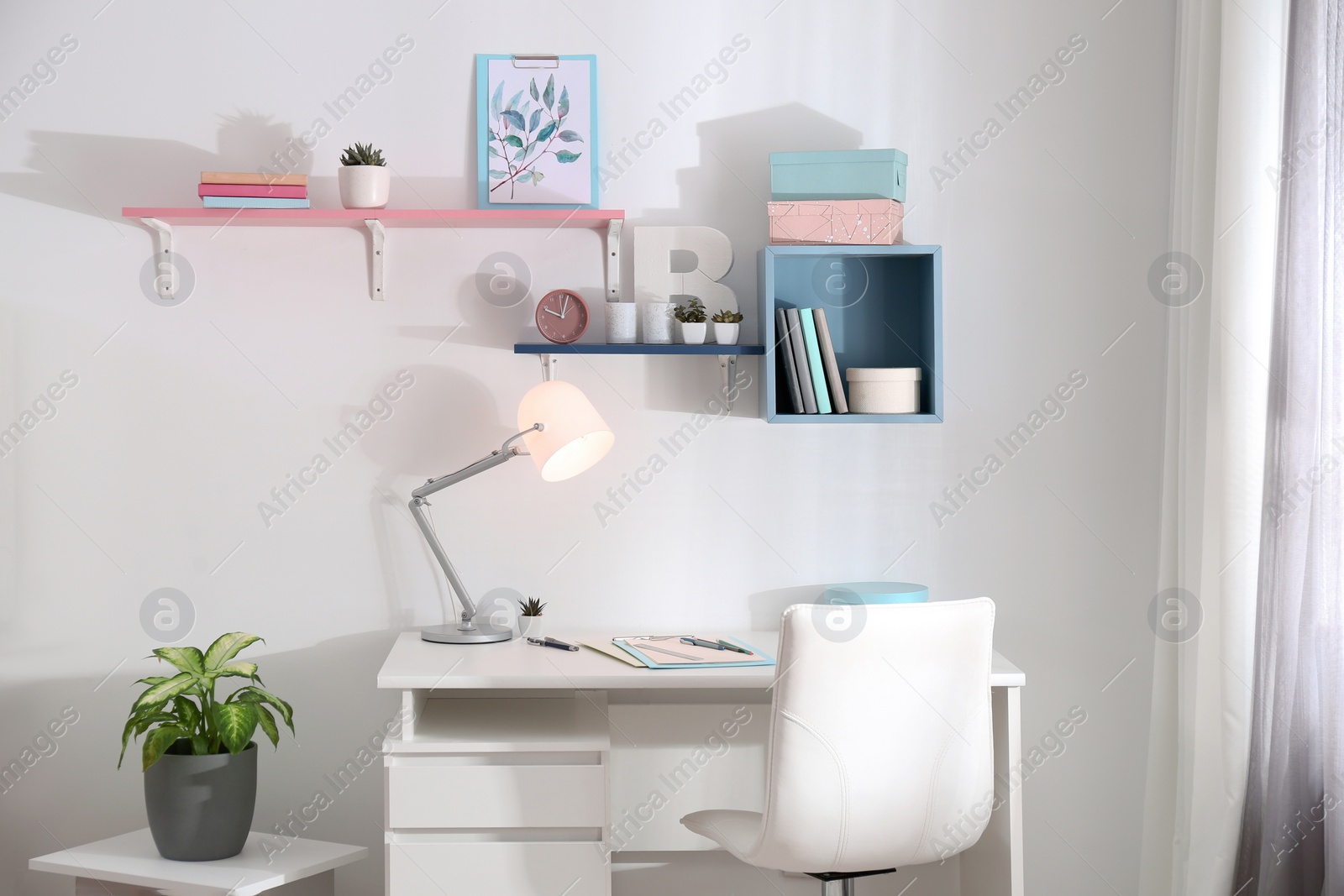 Photo of Stylish room interior with comfortable workplace near window. Design idea