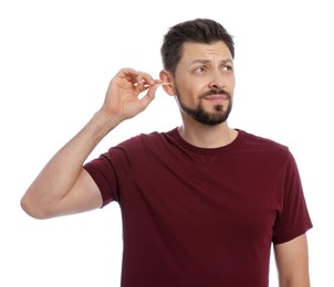 Photo of Emotional man cleaning ears on white background