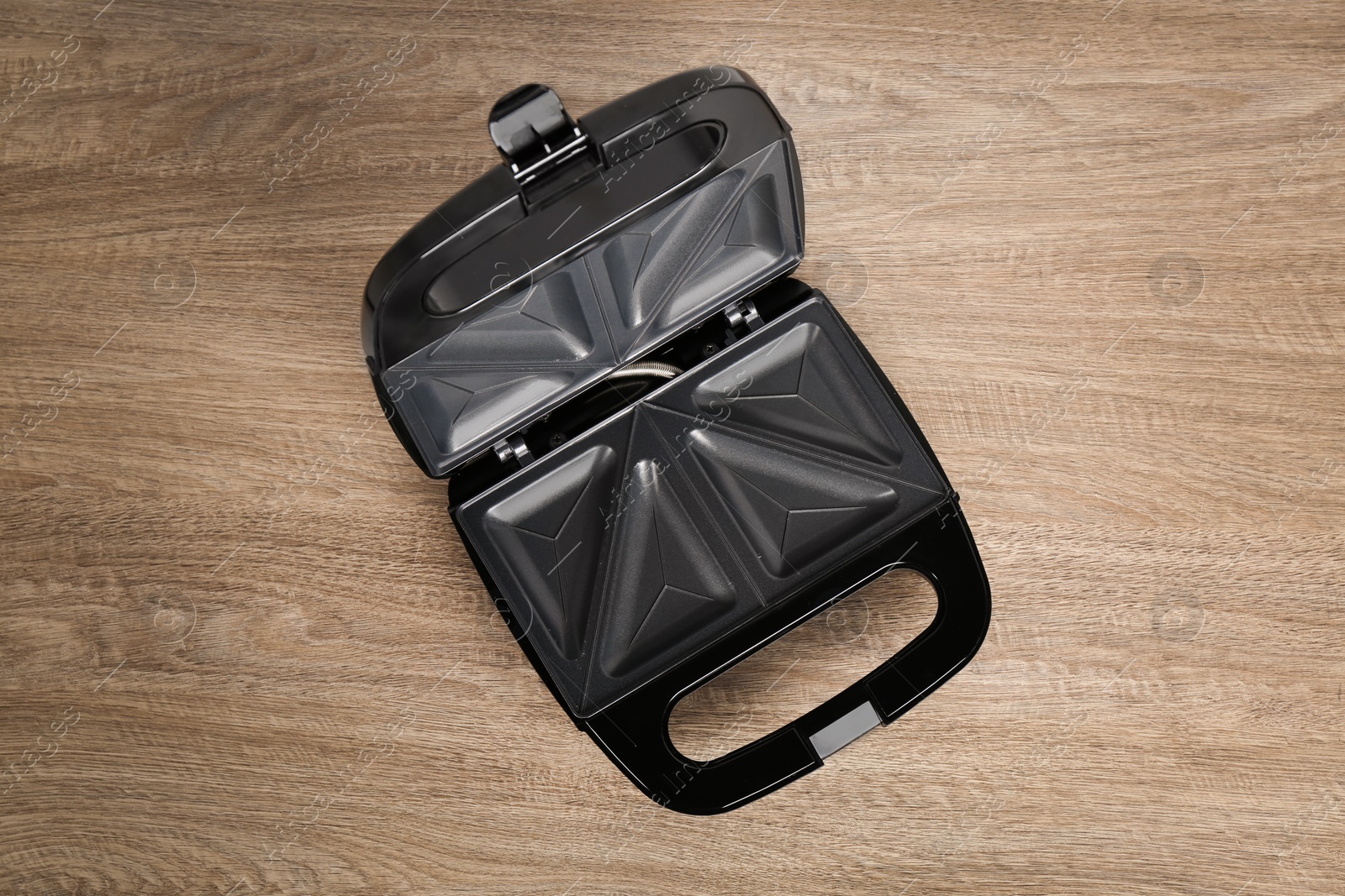 Photo of Open electric sandwich maker on wooden table, top view