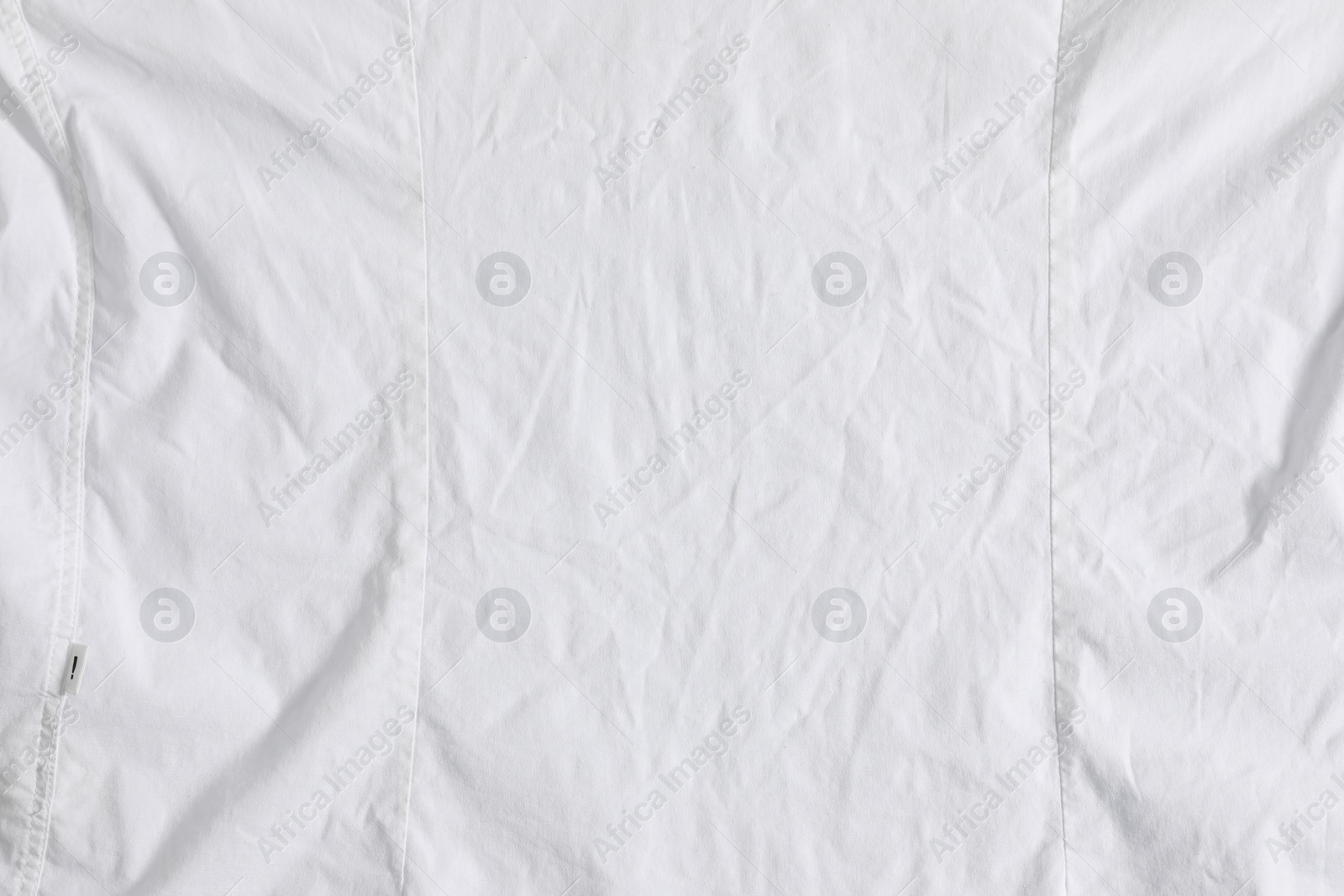 Photo of Crumpled white fabric as background, top view