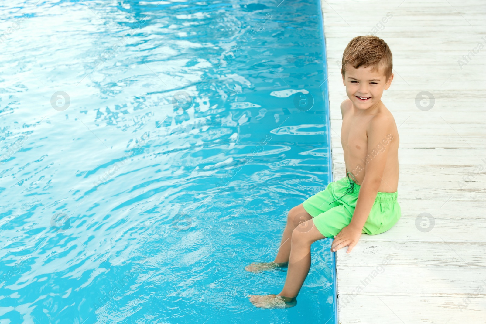 Photo of Little child near outdoor swimming pool. Dangerous situation