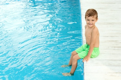 Photo of Little child near outdoor swimming pool. Dangerous situation
