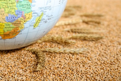 Photo of Globe on wheat grains, closeup. Hunger crisis concept
