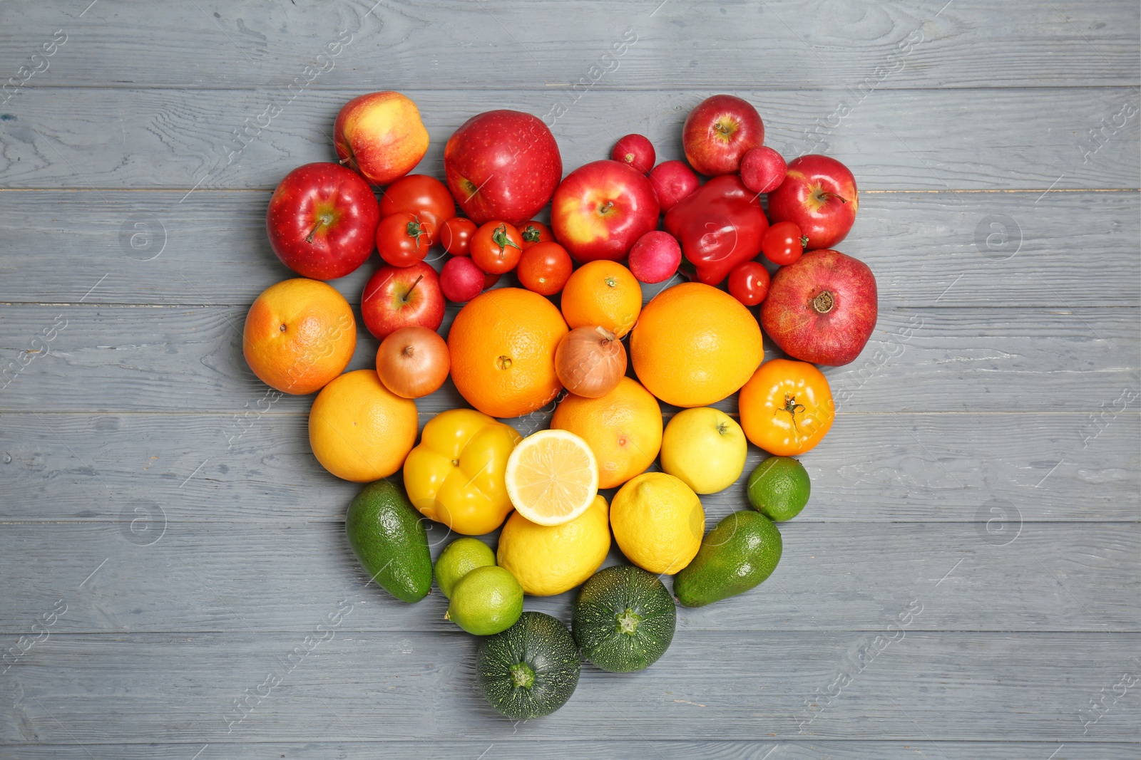 Photo of Heart made of ripe fruits and vegetables in rainbow colors on wooden background, top view