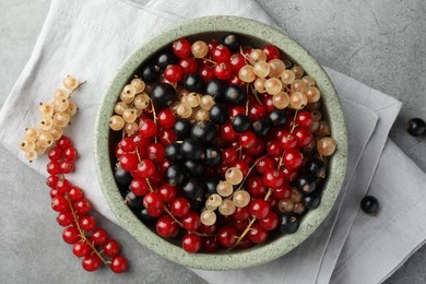Different fresh ripe currants on light grey table, flat lay