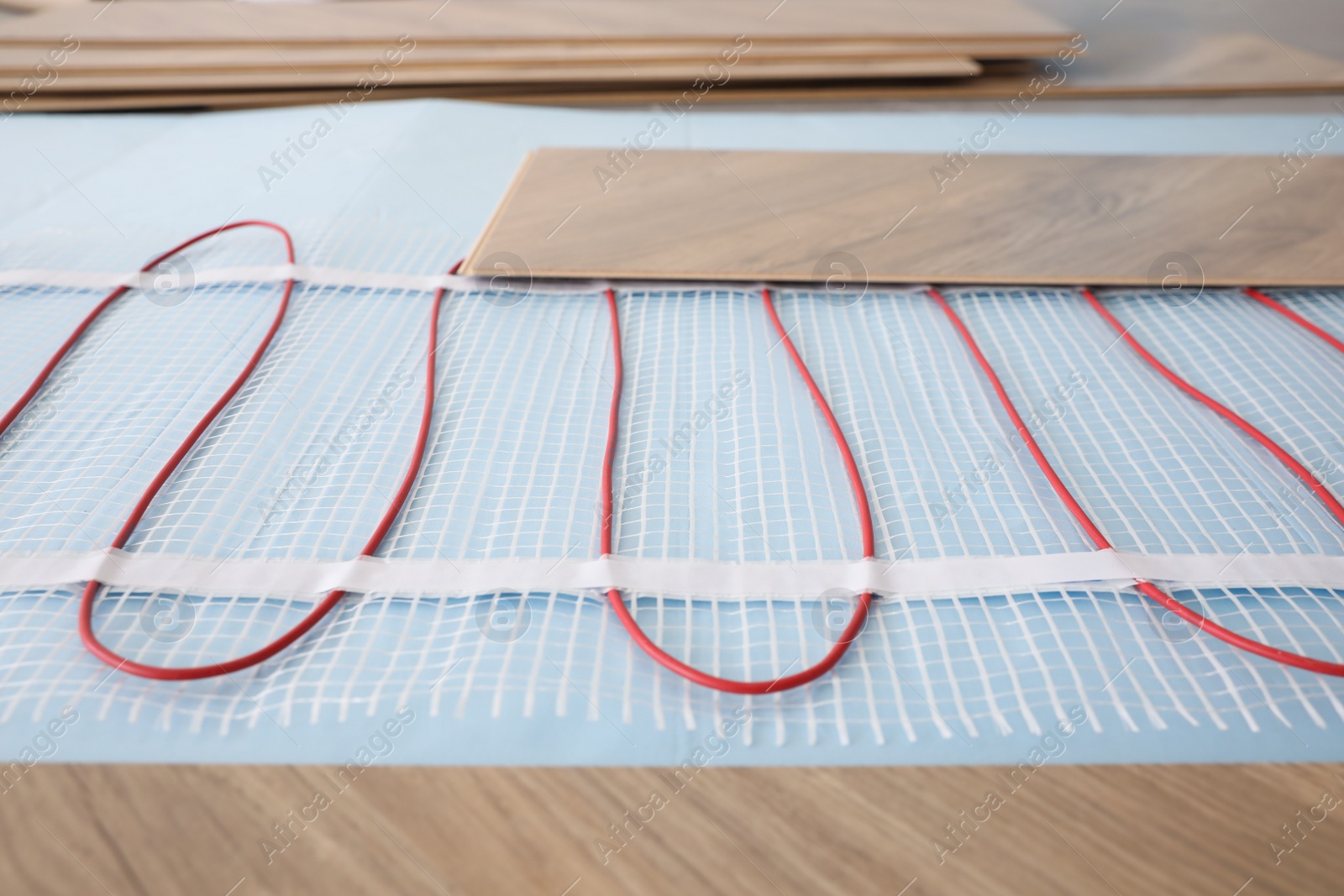 Photo of Installation of modern underfloor trace heating system indoors, closeup