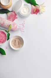 Photo of Flat lay composition with different spa products and beautiful flowers on white table. Space for text