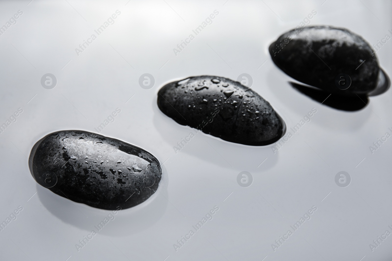 Photo of Spa stones in water, closeup. Zen lifestyle