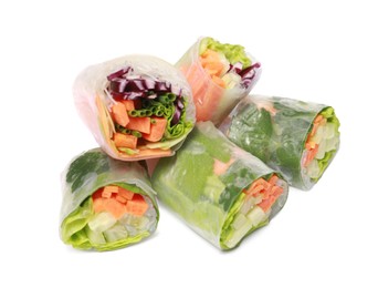 Different delicious spring rolls wrapped in rice paper on white background