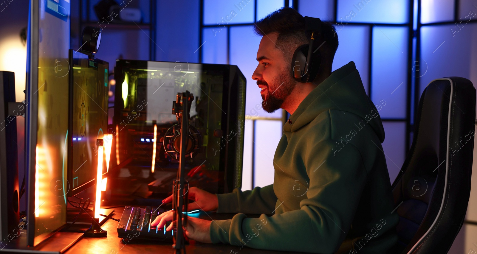 Photo of Man playing video games on computer at table indoors