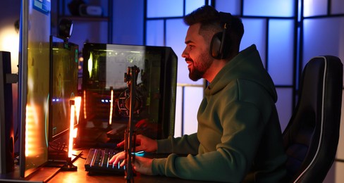 Man playing video games on computer at table indoors