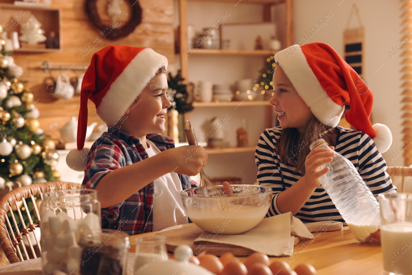 Photo of Cute little children making dough for Christmas cookies at home