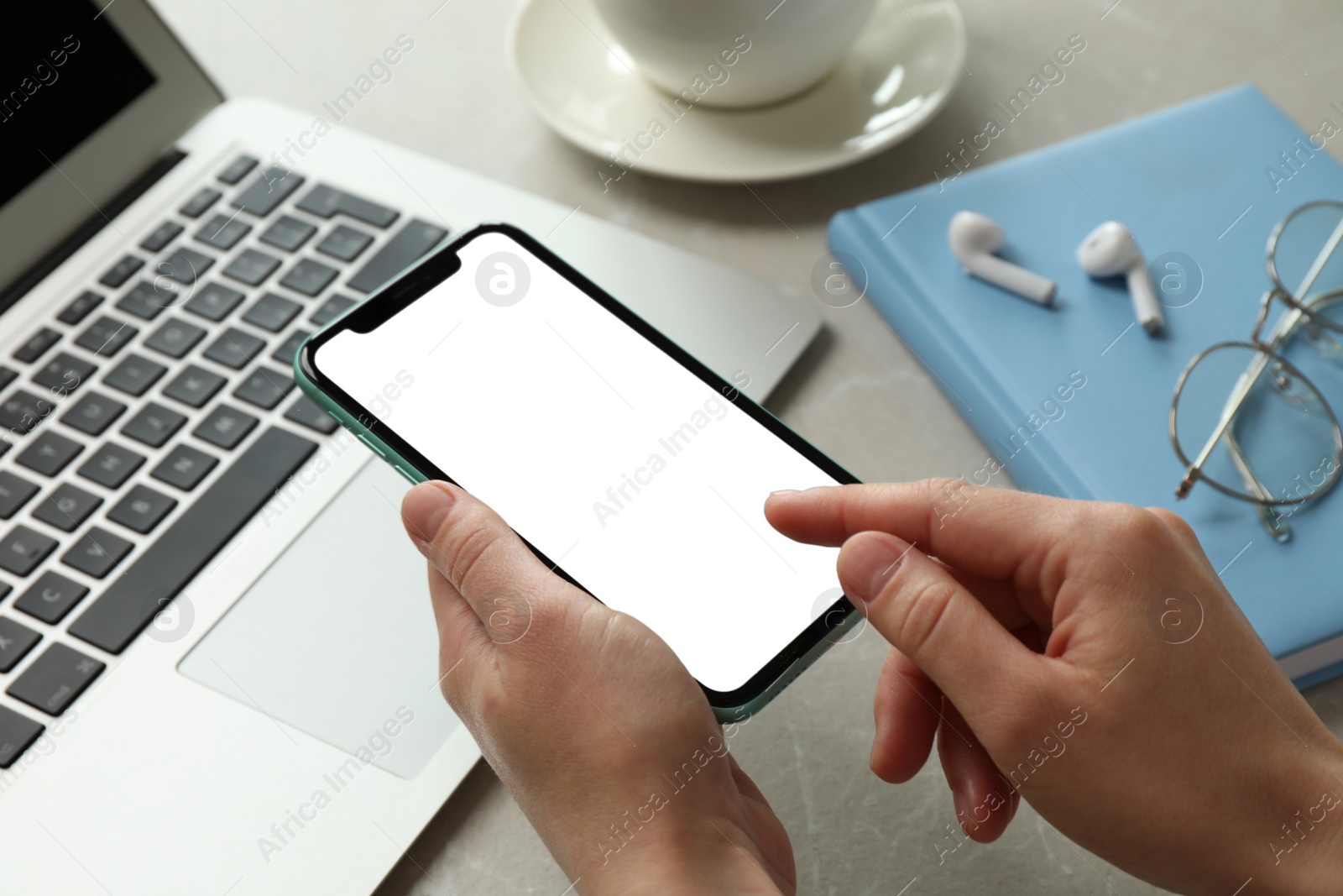 Photo of MYKOLAIV, UKRAINE - JULY 8, 2020: Woman using Iphone 11 Pro Max with blank screen at workplace, closeup