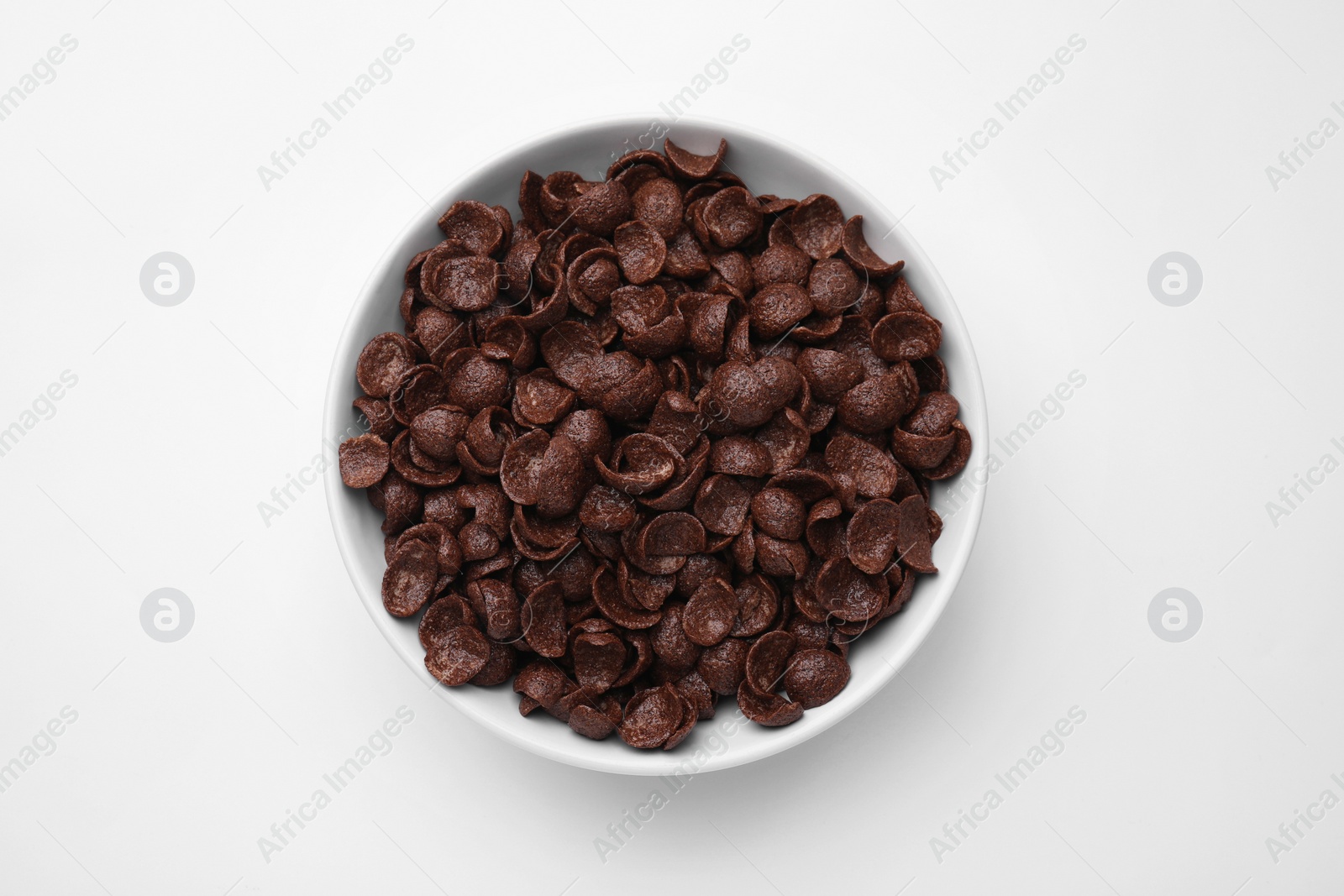 Photo of Breakfast cereal. Chocolate corn flakes in bowl on white table, top view