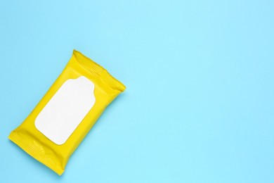 Photo of Wet wipes flow pack on light blue background, top view. Space for text