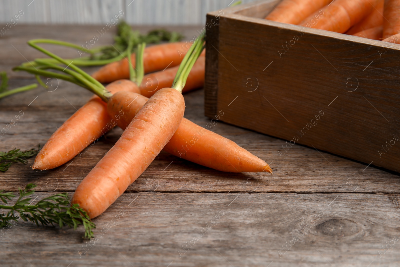 Photo of Ripe carrots on wooden table. Healthy diet