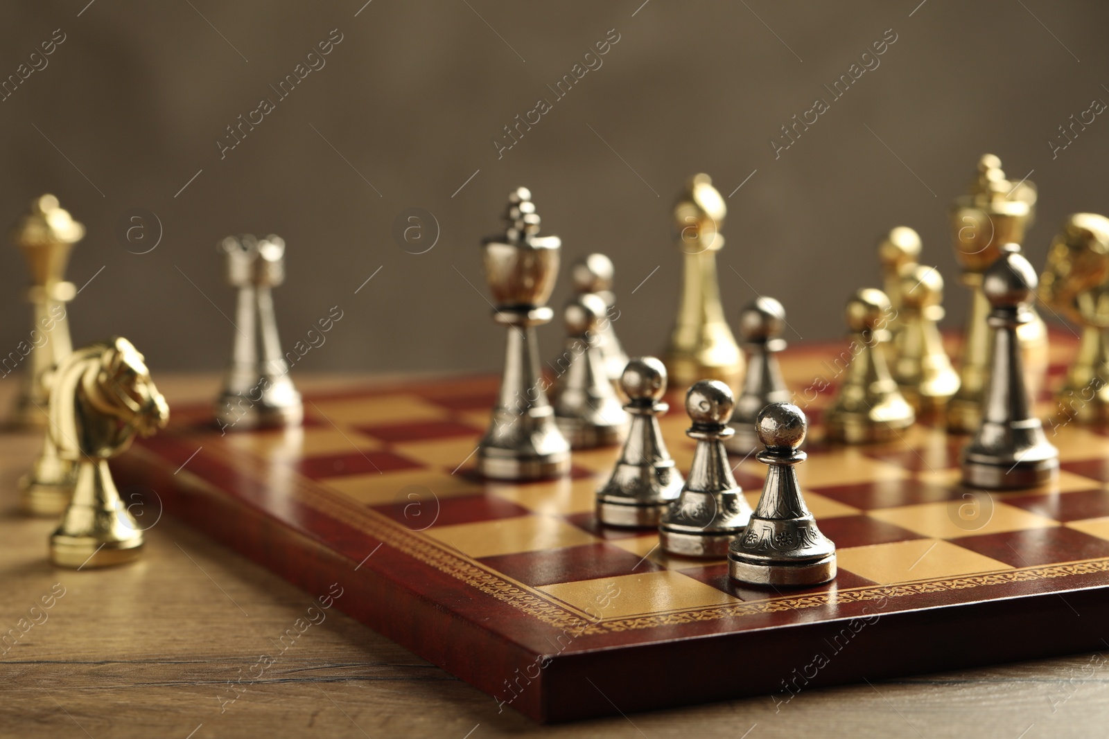 Photo of Chessboard with game pieces on grey background