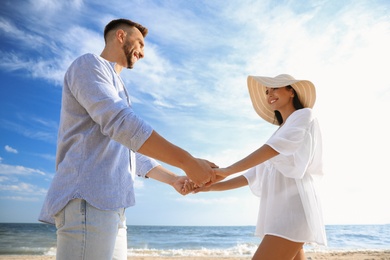 Photo of Happy couple holding hands on beach, low angle view