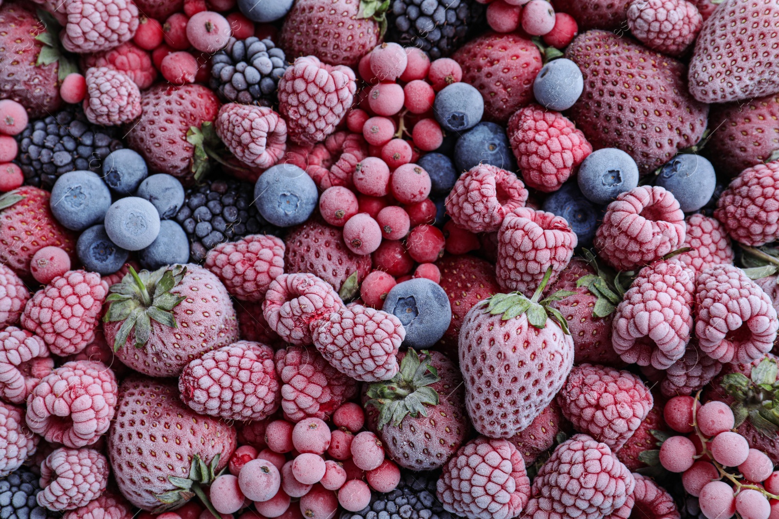 Photo of Mix of different frozen berries as background, top view