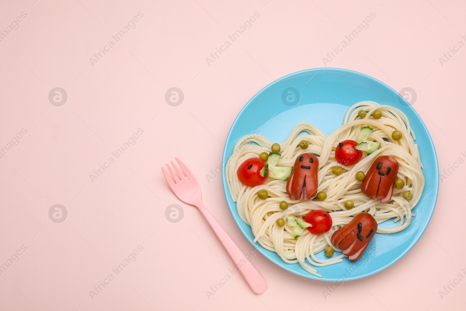 Photo of Creative serving for kids. Plate with cute octopuses made of sausages, pasta and vegetables on pink table, flat lay. Space for text