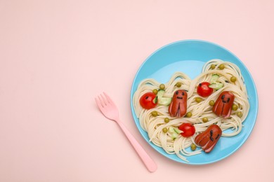 Photo of Creative serving for kids. Plate with cute octopuses madesausages, pasta and vegetables on pink table, flat lay. Space for text