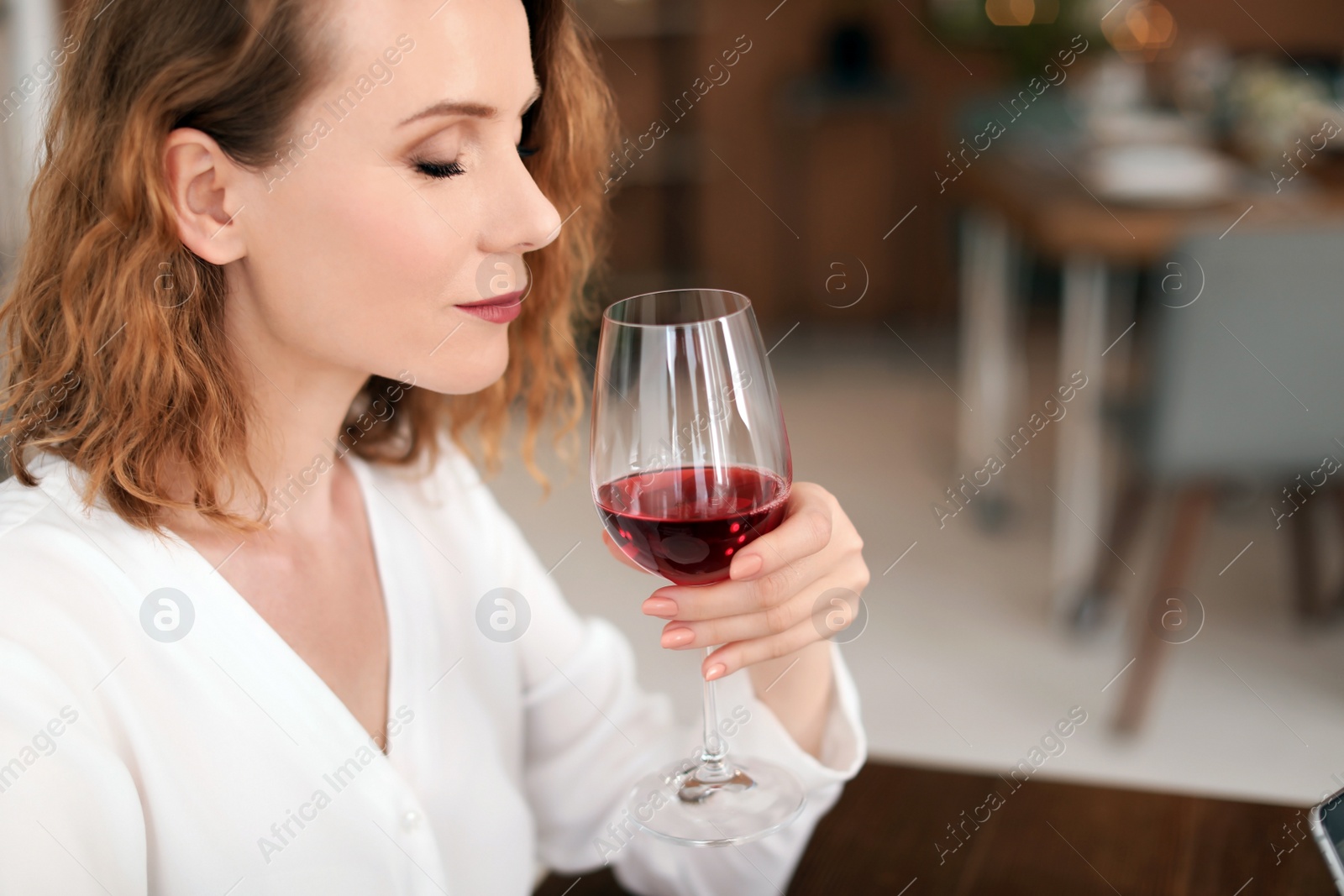 Photo of Woman with glass of delicious wine indoors