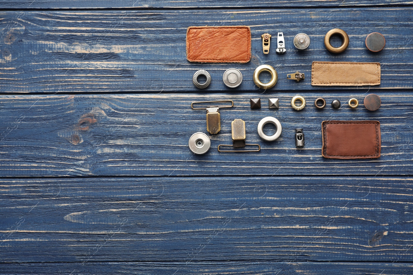 Photo of Flat lay composition with garment accessories for jeans on blue wooden background. Space for text